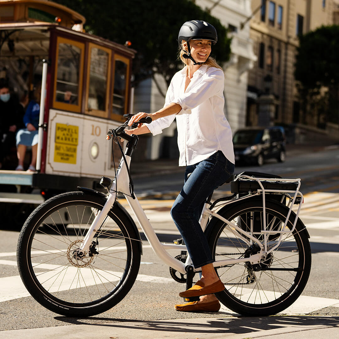 FILE--A woman rides an electric bike past a fashion boutique of